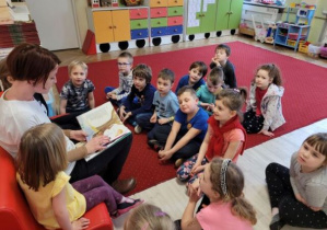 Dzieci słuchają wiersza Juliana Tuwima czytanego przez jedną z mam